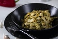 Homemade Italian fettuccine pasta. Pasta with tuna and vegetable sauce. Served in a black plate on a white table. Royalty Free Stock Photo