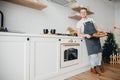 Homemade Italian pizza, handsome young male chef in dark apron holds baking sheet in bright kitchen. Cooking video blog Royalty Free Stock Photo