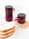 Homemade jam jars with red ribbons and bread slices on white background Royalty Free Stock Photo