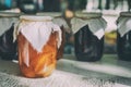 Jars of fruits jam on wooden table. Homemade canned apricots in a jars and sweet apricots on wooden table on dark Royalty Free Stock Photo