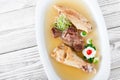 Homemade jelly chicken decorated with greens and eggs on plate on wooden background close up