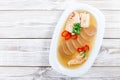 Homemade jelly chicken decorated with greens and eggs on plate on wooden background close up