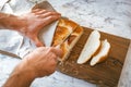 Homemade Jewish traditional challah bread in hands on wooden cutting board