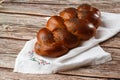 Homemade Jewish traditional challah bread on white napkin on wooden table. Homemade Decorated with poppy seeds. Jewish cuisine. Royalty Free Stock Photo