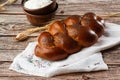 Homemade Jewish traditional challah bread on white napkin on wooden table. Homemade Decorated with poppy seeds. Jewish cuisine. Royalty Free Stock Photo