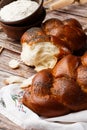 Homemade Jewish traditional challah bread on white napkin on wooden table. Homemade Decorated with poppy seeds. Jewish cuisine. Royalty Free Stock Photo