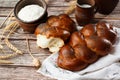 Homemade Jewish traditional challah bread on white napkin on wooden table. Homemade Decorated with poppy seeds. Jewish cuisine. Royalty Free Stock Photo