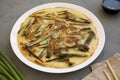 Homemade korean Pajeon scallion pancake on a white plate on a gray background, side view. Asian food. Close-up Royalty Free Stock Photo