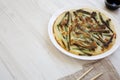 Homemade korean Pajeon scallion pancake on a white plate on a white wooden background, side view. Asian food. Copy space Royalty Free Stock Photo