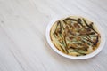 Homemade korean Pajeon scallion pancake on a white plate on a white wooden background, side view. Asian food. Copy space Royalty Free Stock Photo