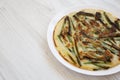 Homemade korean Pajeon scallion pancake on a white plate on a white wooden surface, side view. Asian food. Copy space Royalty Free Stock Photo