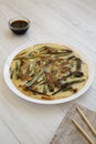 Homemade korean Pajeon scallion pancake on a white plate on a white wooden table, low angle view. Asian food Royalty Free Stock Photo