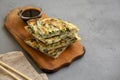 Homemade korean Pajeon scallion pancakes with soy sauce on a rustic wooden board on a concrete background, side view. Asian food. Royalty Free Stock Photo