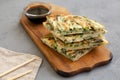 Homemade korean Pajeon scallion pancakes with soy sauce on a rustic wooden board on a gray surface, side view. Asian food. Close- Royalty Free Stock Photo