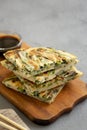 Homemade korean Pajeon scallion pancakes with soy sauce on a rustic wooden board on a gray surface, side view. Asian food. Copy Royalty Free Stock Photo