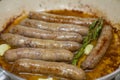 Homemade lamb sausage with rosemary and garlic is fried in a frying pan in olive oil Royalty Free Stock Photo