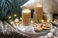 Homemade latte in glass cups, served with gingerbread on the background of plaid, pillows and garlands Royalty Free Stock Photo