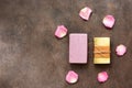 Homemade lavender and herbal soap bars decorated with rose petals. Dark brown grunge background. Top view, flat lay Royalty Free Stock Photo