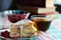 Homemade layer cake with raspberry vanilla custard dripping decorated with frozen berry