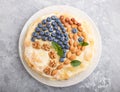 Homemade layered Napoleon cake with milk cream. Decorated with blueberry, almonds, walnuts, hazelnuts, mint on a gray concrete Royalty Free Stock Photo