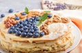 Homemade layered Napoleon cake with milk cream. Decorated with blueberry, almonds, walnuts, hazelnuts, mint on a gray concrete Royalty Free Stock Photo