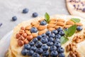 Homemade layered Napoleon cake with milk cream. Decorated with blueberry, almonds, walnuts, hazelnuts, mint on a gray concrete Royalty Free Stock Photo