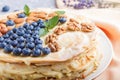 Homemade layered Napoleon cake with milk cream. Decorated with blueberry, almonds, walnuts, hazelnuts, mint on a gray concrete Royalty Free Stock Photo