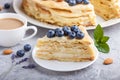 Homemade layered Napoleon cake with milk cream. Decorated with blueberry, almonds, walnuts, hazelnuts, mint on a gray concrete Royalty Free Stock Photo