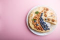 Homemade layered Napoleon cake with milk cream. Decorated with blueberry, almonds, walnuts, hazelnuts, mint on a pastel pink Royalty Free Stock Photo