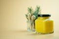 Homemade lemon curd in small glass jar with black lid on yellow background Royalty Free Stock Photo