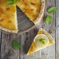Homemade lemon tart. Sweet citrus dessert with mint leaves anc jelly cream. Rustic wooden background. Square iamge. Royalty Free Stock Photo