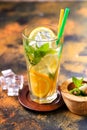 Homemade lemonade in a glass, lime, lemons and mint on a wooden board
