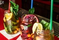 Homemade lemonade ice tea colorful icetea drink with fresh sweet fruits mint leaves in glass on the rocks with straw