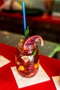 Homemade lemonade ice tea colorful icetea drink with fresh sweet fruits mint leaves in glass on the rocks with straw Royalty Free Stock Photo