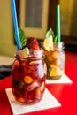 Homemade lemonade ice tea colorful icetea drink with fresh sweet fruits mint leaves in glass on the rocks with straw Royalty Free Stock Photo