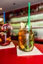 Homemade lemonade ice tea colorful icetea drink with fresh sweet fruits mint leaves in glass on the rocks with straw