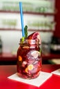 Homemade lemonade ice tea colorful icetea drink with fresh sweet fruits mint leaves in glass on the rocks with straw Royalty Free Stock Photo