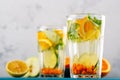 Homemade lemonade with lemon, orange, sea buckthorn and mint in glasses on white background, summer drinks Royalty Free Stock Photo