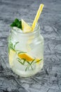 Homemade lemonade with lemon, mint, rosemary in a mason jar on concrete background. Royalty Free Stock Photo