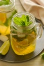 Homemade lemonade with lime, mint in a mason jar on a wooden rustic table. Summer drinks