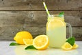 Lemonade in a mason jar glass with lemons, side view against rustic wood Royalty Free Stock Photo