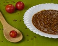 Tasty Homemade Lentil soup with Pork Sausages called Chorizo and Blood sausage called Morcilla in a dish decorated with tomatoes Royalty Free Stock Photo