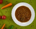 Tasty Homemade Lentil soup with Pork Sausages called Chorizo and Blood sausage called Morcilla in a dish decorated with vegetables