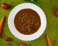 Tasty Homemade Lentil soup with Pork Sausages called Chorizo and Blood sausage called Morcilla in a dish decorated with vegetables Royalty Free Stock Photo