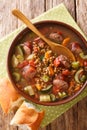 Homemade lentil soup with sausages and vegetables close-up in a plate. vertical top view Royalty Free Stock Photo