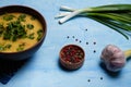 Homemade lentils or pea soup served with parsley, onions, garlic and aromatic pepper set on blue table. Royalty Free Stock Photo