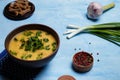 Homemade lentils or pea soup served with parsley, onions, garlic pepper and rye bread crackers on blue table Royalty Free Stock Photo