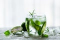 Homemade lime lemonade with cucumber, rosemary and ice, white background. Cold beverage for hot summer day. Copyspace Royalty Free Stock Photo