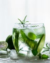 Homemade lime lemonade with cucumber, rosemary and ice, white background. Cold beverage for hot summer day. Copyspace Royalty Free Stock Photo