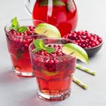 Homemade lingonberry and lime punch or limeade in a glass and pitcher on gray background, square Royalty Free Stock Photo